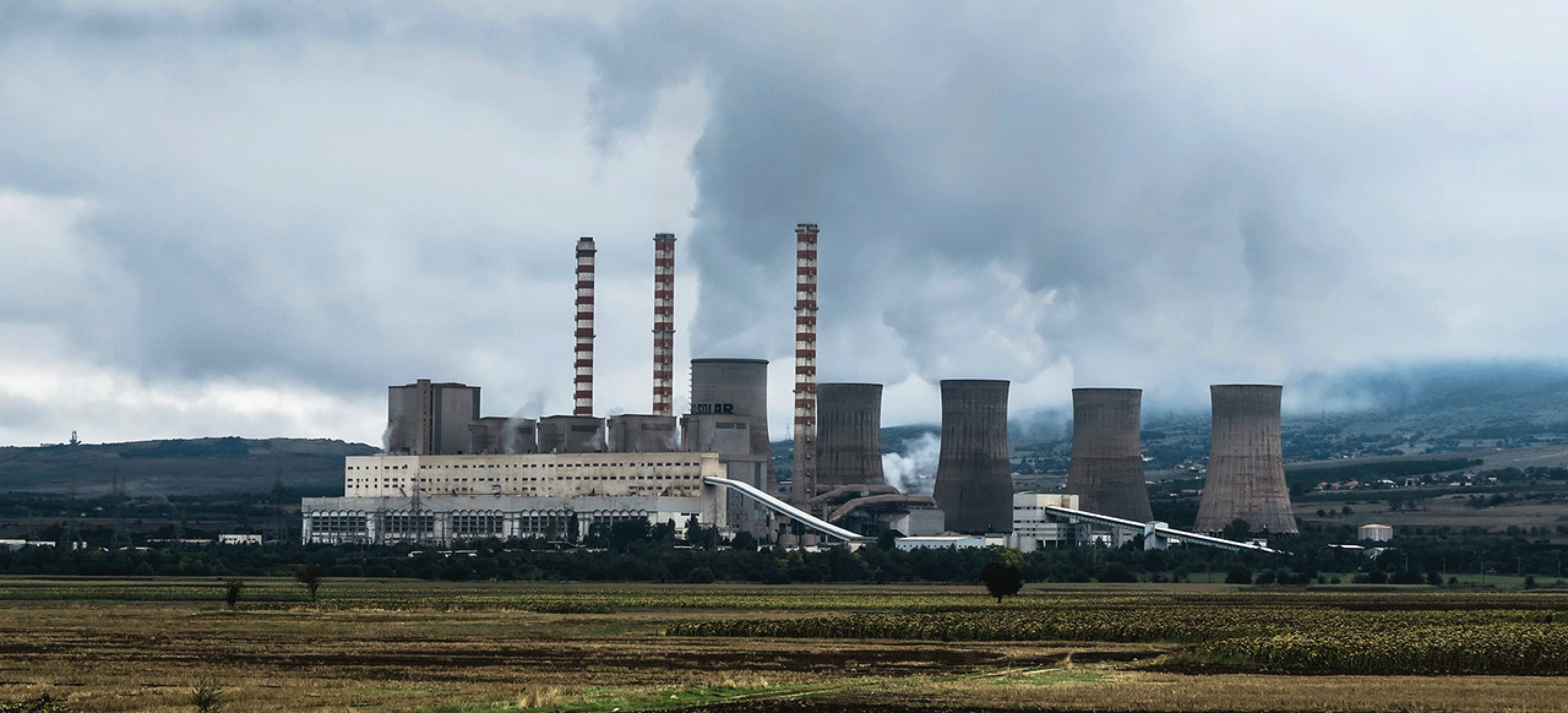 Empresa com chaminés emitindo CO2